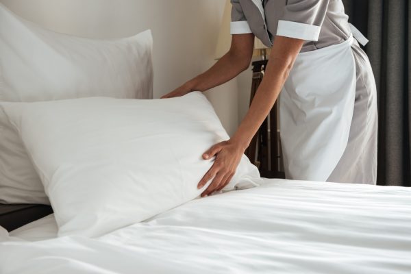 chambermaid-making-bed-hotel-room